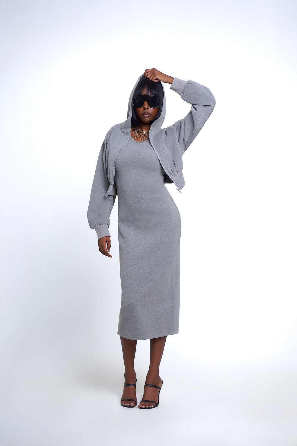 The Essential Muse Set, featuring a heather gray fitted midi dress and matching cropped zip-up hoodie, styled with oversized sunglasses and heels