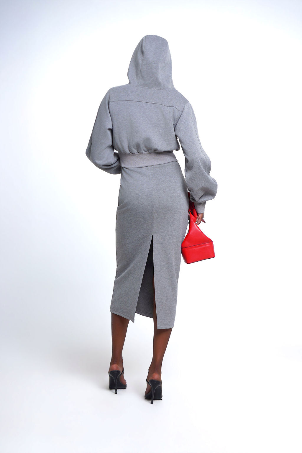 The Essential Muse Set, featuring a heather gray fitted midi dress and matching cropped zip-up hoodie, styled with oversized sunglasses and heels